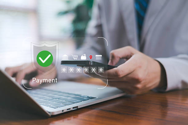 istock A secure online payment concept showing a person using a smartphone and laptop with digital verification icons, representing safe transactions, financial security, mobile banking, and modern digital finance systems. 2246558528