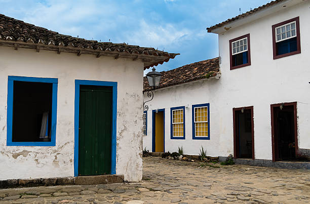 Rear view of a diverse group of friends walking together along a cobblestone street in a historic town during a summer trip