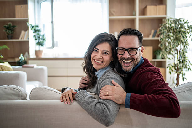 istock Happy couple relaxing at home smiling together 2246568153