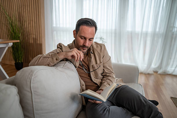 istock Man relaxing at home reading book enjoying leisure 2246570421