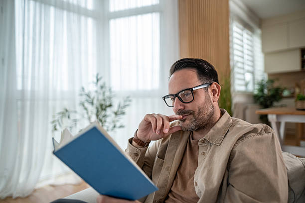 Man reading book relaxing at home