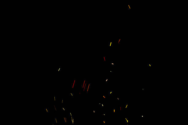 Burning red hot sparks fly from large fire in the night sky. Beautiful abstract background on the theme of fire, light and life.