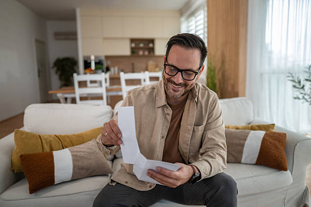 istock Happy man reading good news letter at home 2246571966