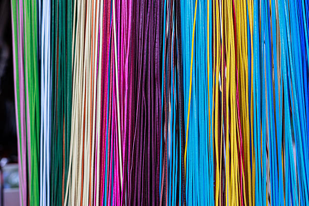 istock Close-up of many colorful leather or fabric strips hanging vertically in rows, showcasing vibrant shades of red, blue, orange, green, pink, and beige with rich textures 2246572707