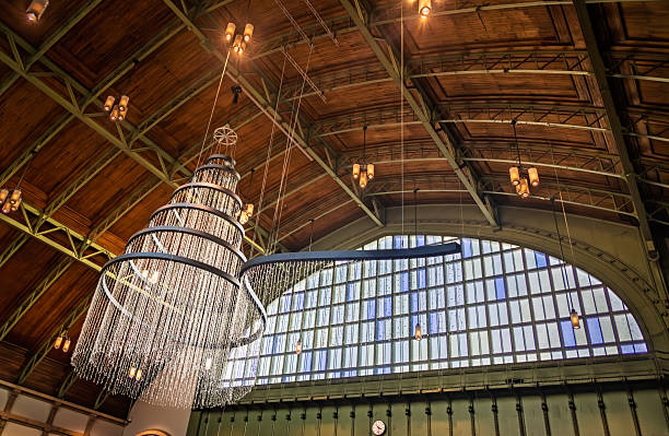 Basel, Switzerland - November 16, 2024: Magnificent Christmas tree light fixture hangs from the wooden ceiling of the historic SBB train station