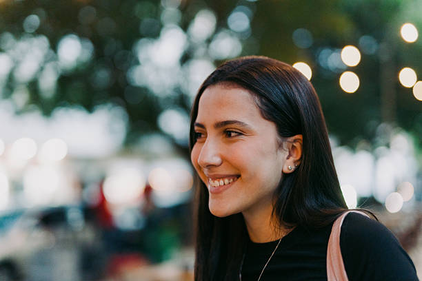 istock Young woman smiling at a city park 2246580059