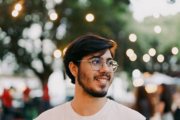 istock Young man walking and smiling at a city park 2246580071