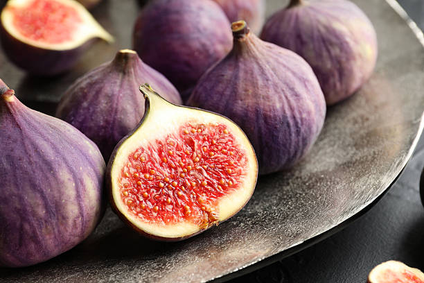 istock Whole and cut figs on table, closeup 2246581467