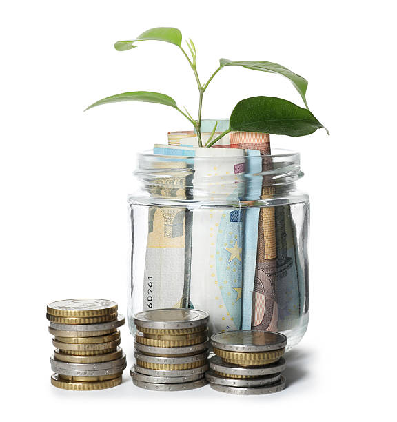 istock Glass jar with money and sprout isolated on white 2246584940