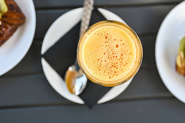 Refreshing orange juice with a spoon on a graphic napkin, offering a cafe breakfast