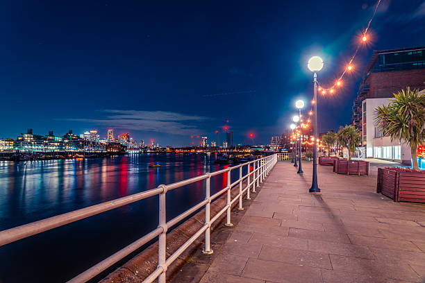istock Illuminated walkway by the river thames in london at night 2246595925