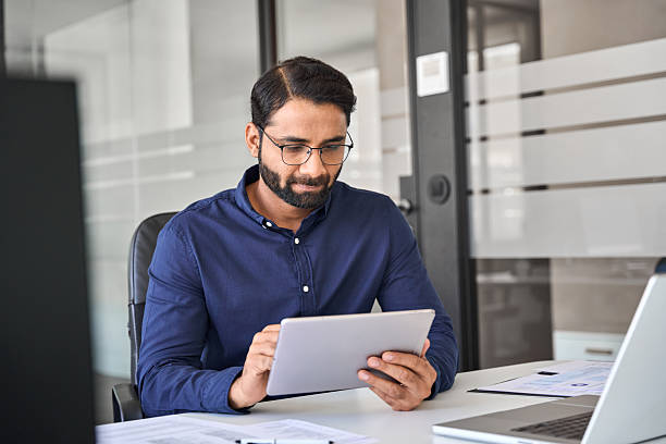 istock Busy Indian business man executive manager using tablet in office. 2246601184