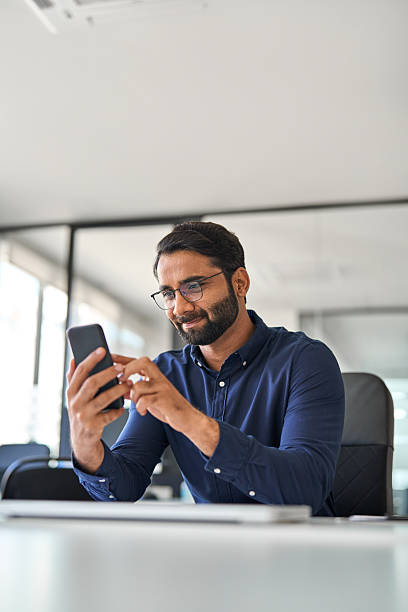 istock Professional Indian businessman office worker using cellphone at work. Vertical 2246601190
