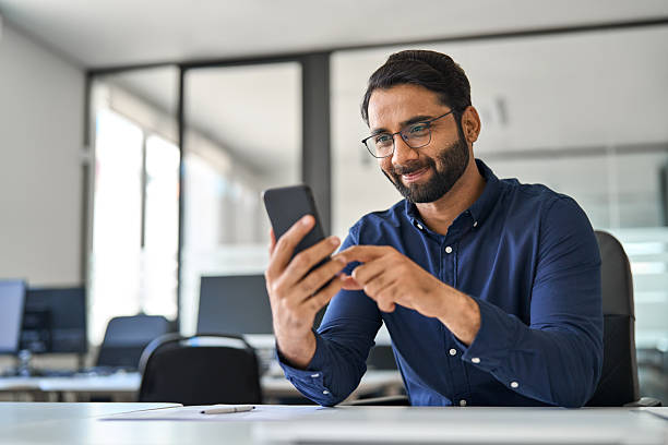 istock Busy Indian business man executive using mobile phone working in office. 2246601191