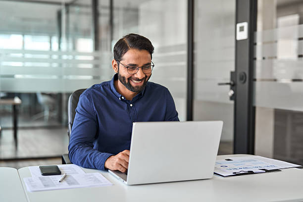 istock Happy Indian business man looking at laptop using computer working in office. 2246601207