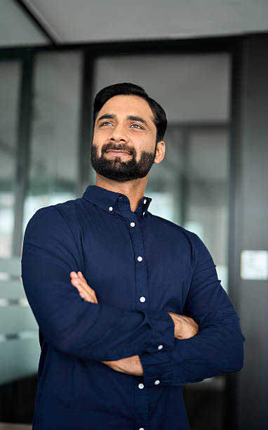 istock Confident Indian businessman looking away standing in office, vertical. 2246601231