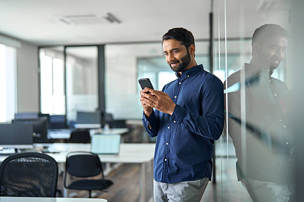 istock Busy Indian businessman using mobile phone working standing in office. 2246601236
