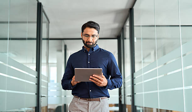 istock Busy Indian business man project manager using tab walking in office. 2246601251