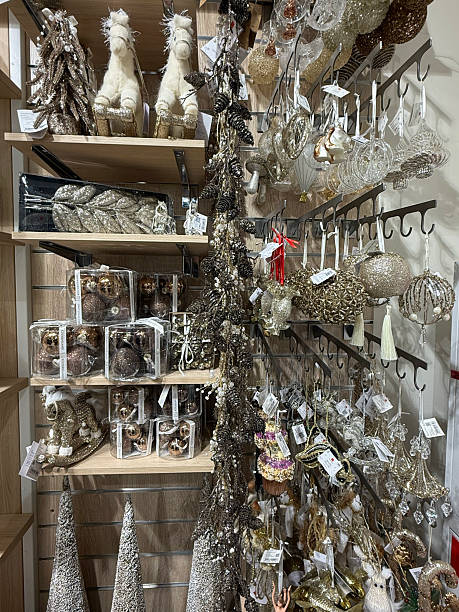 istock Christmas tree decorations in a storefront. Gold, silver holiday ornaments hang in the display case. Colorful balls, horses, bells. Seasonal sale, a showcase filled with glitter New Years baubles 2246609096