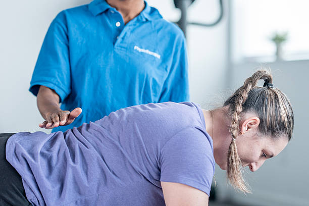 istock Chiropractor Demonstrates Back Adjustment On Woman During Therapy Session For Posture Relief 2246610559