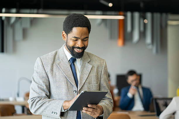 istock Smiling businessman using digital tablet in modern office 2246613054