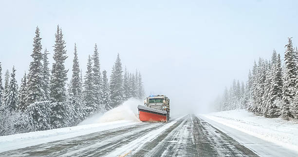 A snow plow makes it way down the highway. The snow is cleared to make Winter driving easier for the public.