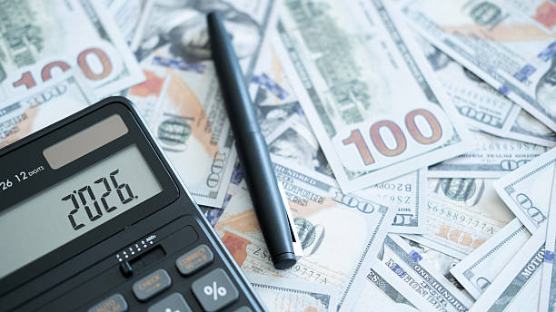 istock A black calculator showing “2026” placed on scattered US dollar bills, symbolizing financial planning, budgeting, and upcoming economic goals. 2246617723