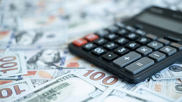 istock Soft-focused view of US dollar bills with a calculator, emphasizing financial planning, spending analysis, and money calculations. 2246617728