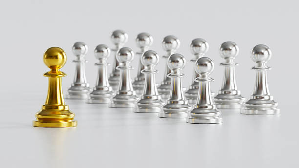 istock Golden Chess Pawn Standing Uniquely with Courage Amid Silver Pawns on Light Background 2246619524