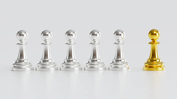 istock Golden Chess Pawn Standing Uniquely with Courage Apart from Silver Pawns on Light Background 2246619540