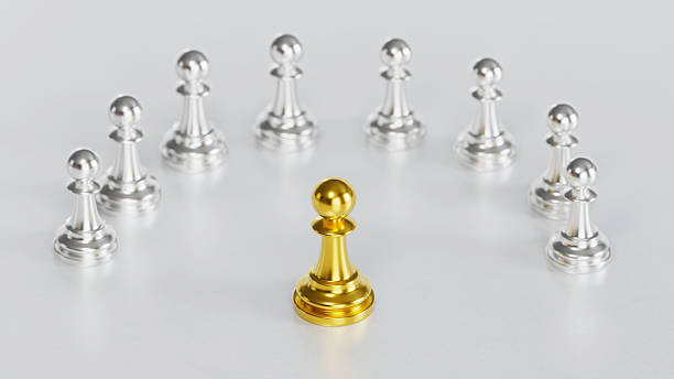 istock Golden Chess Pawn Standing Centrally with Leadership Amid Silver Pawns on Light Background 2246619558