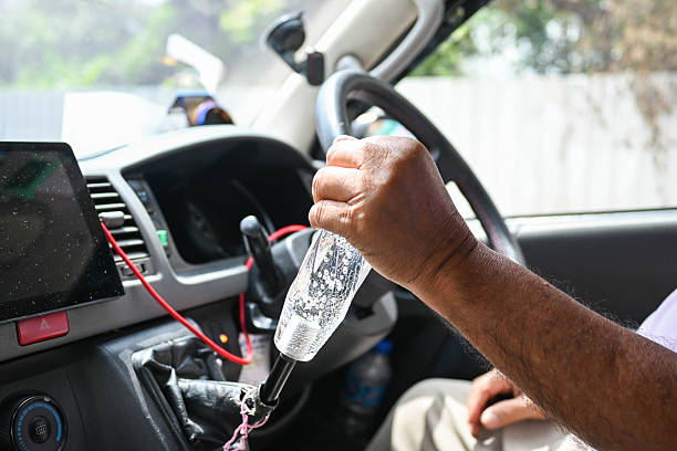 The man keeps his hand on the gearbox