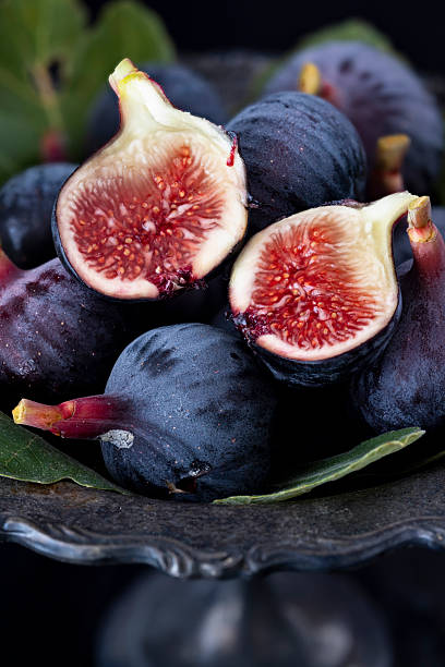 Close-Up of Fresh Ripe Figs In Dark Bowl With Leaves