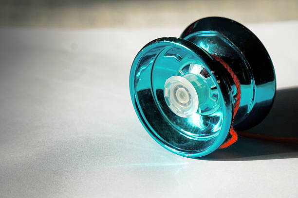 A colorful yo - yo with a string, used for recreational spinning and play.