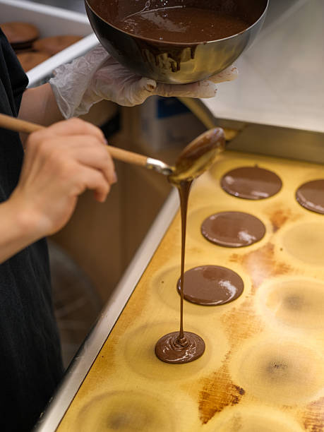 istock The Process of Chocolate Making: Hand-Pouring Chocolate Sauce into Molds 2246628638