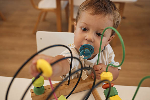Happy baby boy is having fun in the kindergarten.
