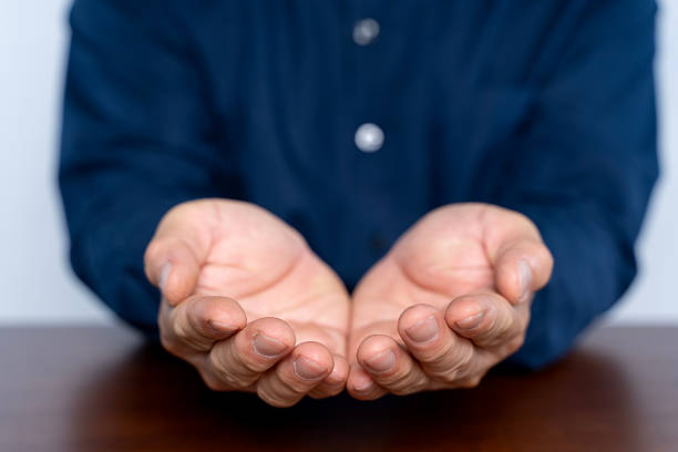 A close-up image of open hands extended forward, symbolizing giving, support, help, compassion, trust, and human connection. This gesture conveys offering, kindness, generosity, and emotional openness