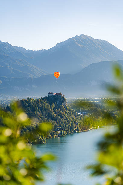 Bled Castle at Sunrise with Hot Air Balloon Floating Above in Vertical View