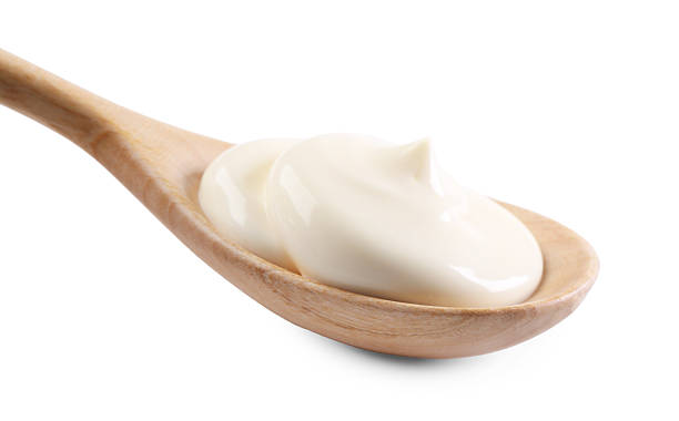 istock Natural yogurt in wooden spoon isolated on white 2246638138