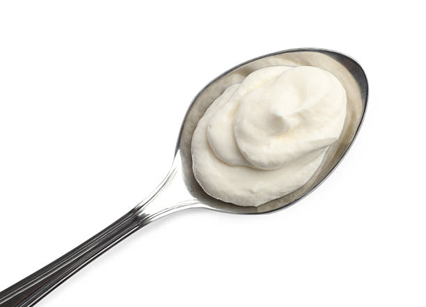 istock Sour cream in spoon isolated on white, top view 2246638215