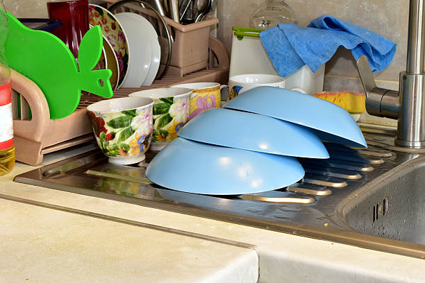 Washed blue plates dry on the kitchen sink.