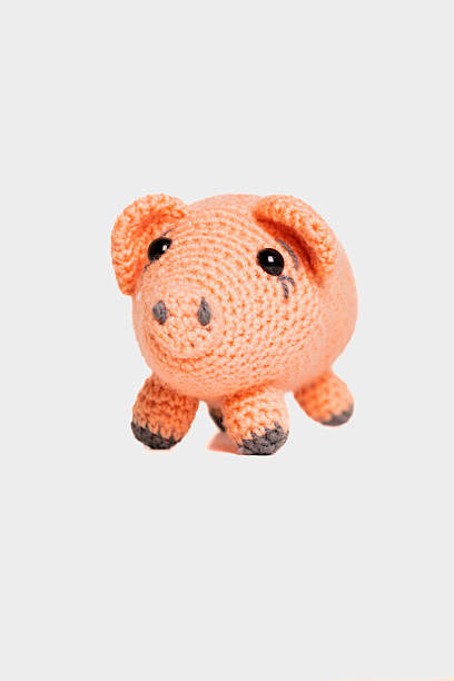 istock A small, hand-crocheted pig toy features a soft orange body and charming details. Ideal for children or as a decorative item in any playful setting. 2246643264