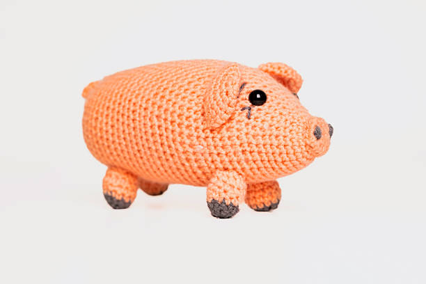 istock A small, hand-crocheted pig toy features a soft orange body and charming details. Ideal for children or as a decorative item in any playful setting. 2246643307