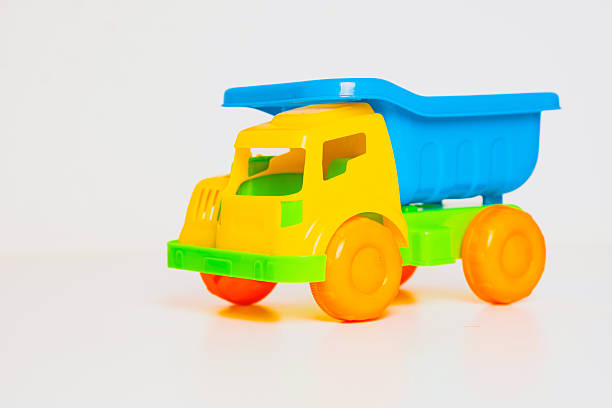 istock Brightly colored plastic toy truck sitting on a white surface, perfect for imaginative playtime 2246644602