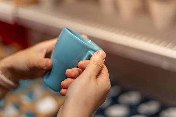 istock Close-up of Hands Holding a Blue Ceramic Mug in a Cozy Kitchen Setting 2246645314
