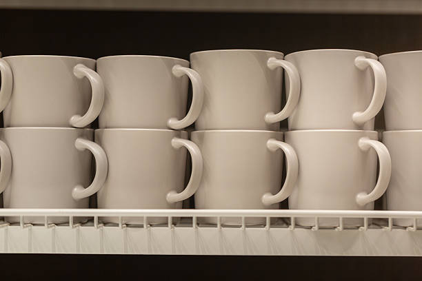 istock Neatly Arranged White Coffee Mugs on a Shelf in a Kitchen Cabinet 2246645349