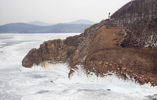 istock Rocks and lighthouse at Cape Vasiliev in winter 2246646186