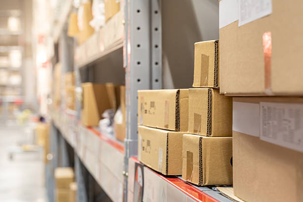 istock Stacked Cardboard Boxes on Shelving Units in a Warehouse Storage Area 2246646270