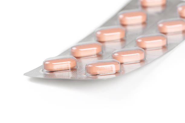 istock Pack of pink capsules arranged in a row on a foil backing 2246647420