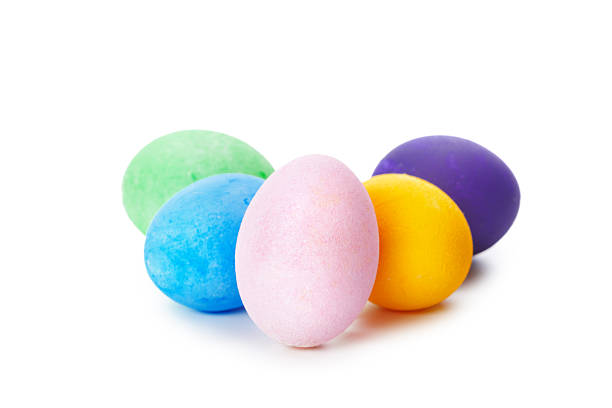 Bright pastel eggs in various colors sit together on a clean, white surface, perfect for decoration.